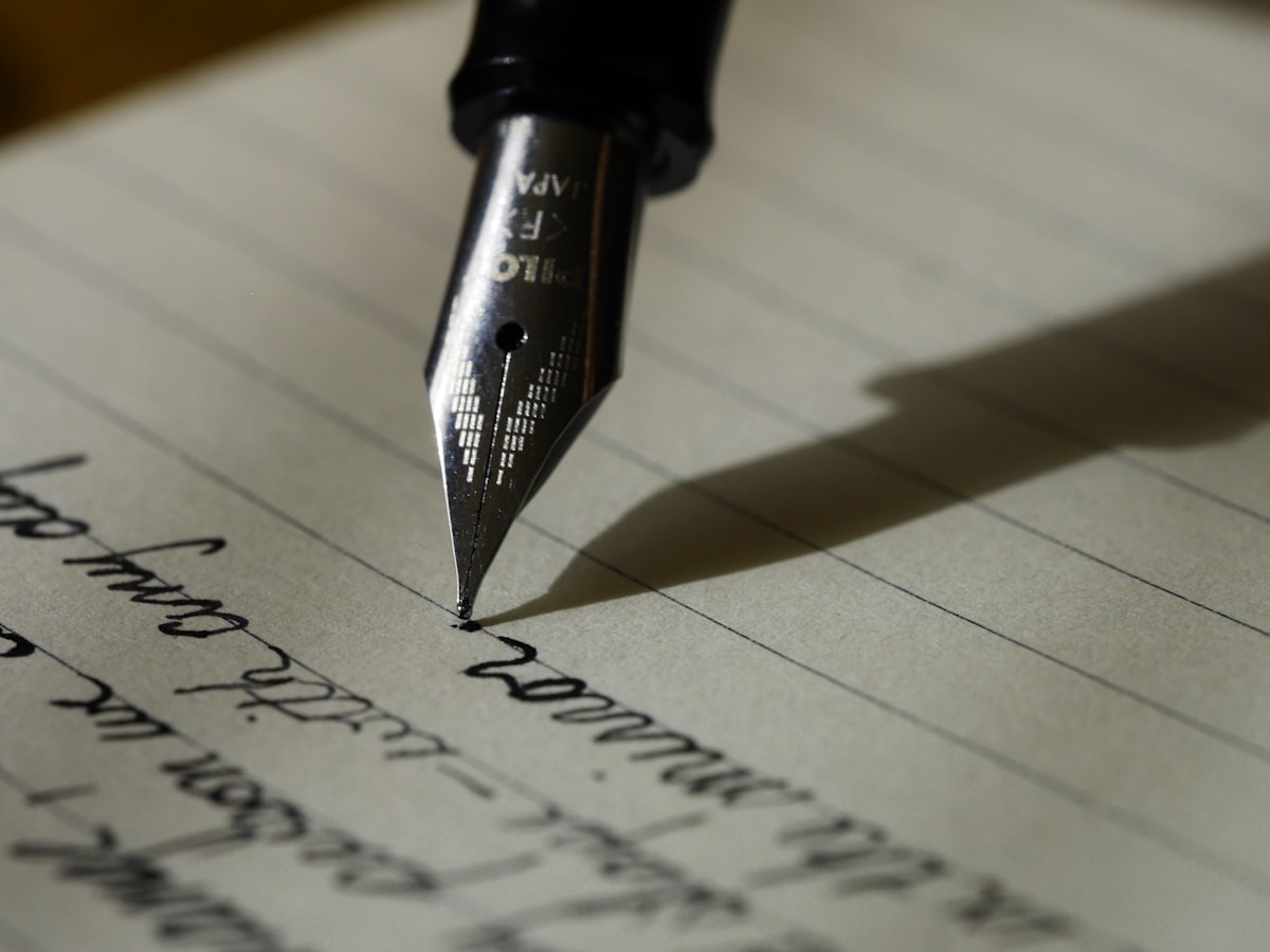 Notebook and pen beside a laptop during a copywriting session